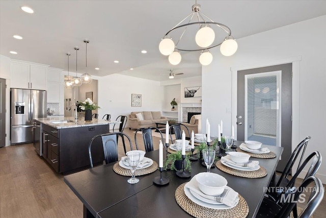 2895 Evening Sun Dr, Twin Falls, ID 83301 - dining room with dark wood-type flooring, a fireplace, a ceiling fan, and recessed lighting
