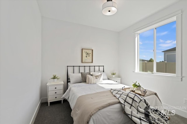 bedroom with baseboards and dark colored carpet