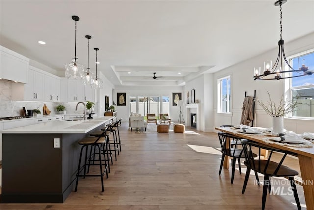 dining space featuring recessed lighting, light wood-style floors, plenty of natural light, and a glass covered fireplace