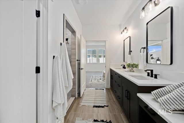 full bathroom with walk in shower, a sink, and double vanity
