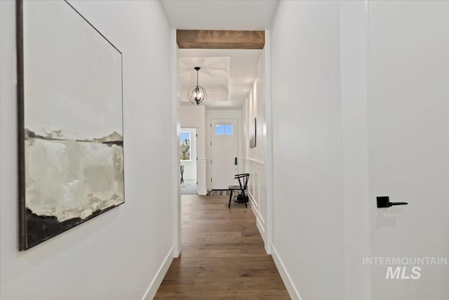 hall featuring baseboards, beamed ceiling, and dark wood-style floors