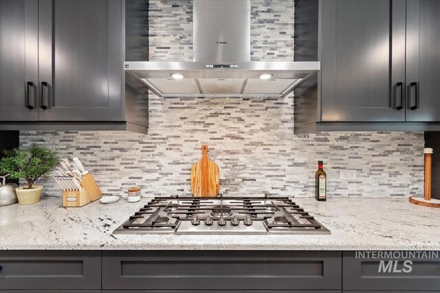 659 N Palmetto Dr, Eagle, ID 83616 - kitchen with gray cabinets, stainless steel gas cooktop, backsplash, and wall chimney range hood