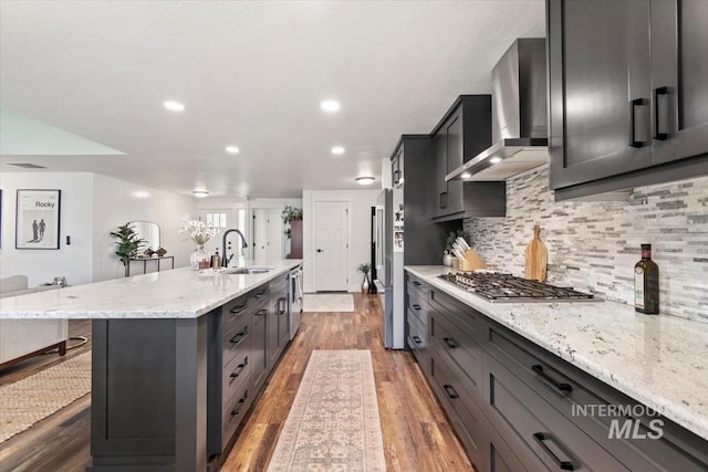 659 N Palmetto Dr, Eagle, ID 83616 - kitchen featuring wall chimney range hood, appliances with stainless steel finishes, wood finished floors, and a sink