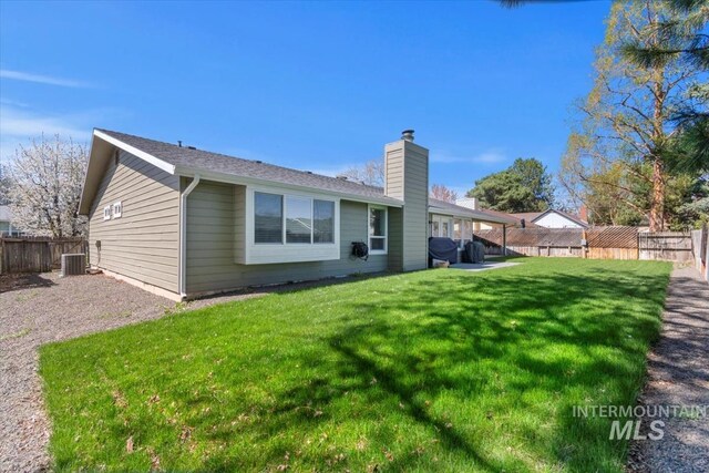 659 N Palmetto Dr, Eagle, ID 83616 - rear view of house featuring a lawn, a fenced backyard, and a chimney