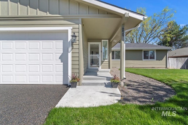 659 N Palmetto Dr, Eagle, ID 83616 - doorway to property with board and batten siding, aphalt driveway, a yard, and a garage