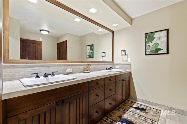 bathroom featuring tile patterned floors, vanity, and tasteful backsplash