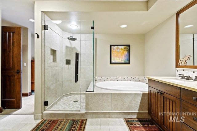 bathroom with tile patterned floors, vanity, and shower with separate bathtub