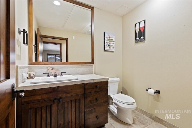 bathroom with tile patterned floors, vanity, toilet, and tasteful backsplash