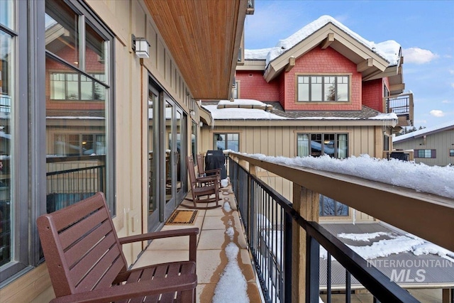 view of snow covered back of property