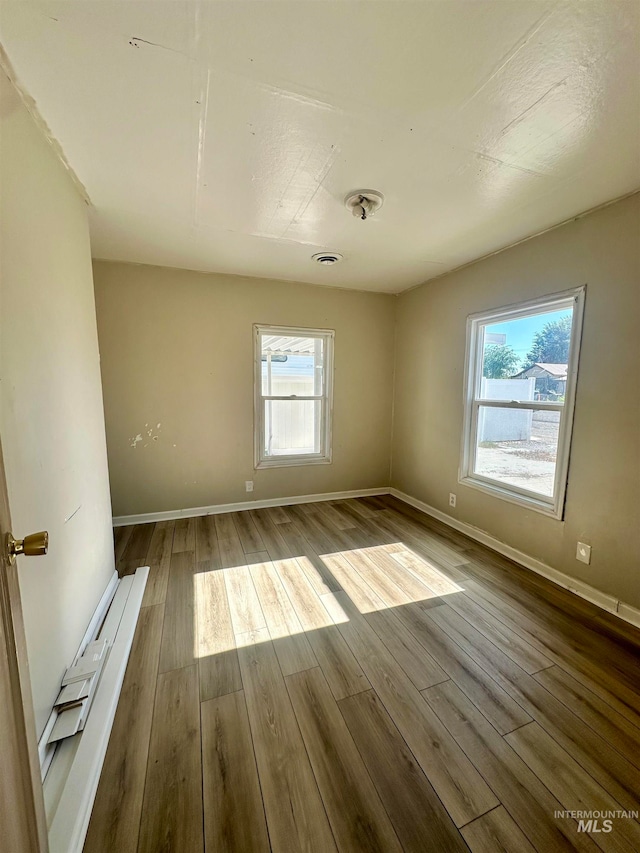 empty room with light hardwood / wood-style floors and a healthy amount of sunlight