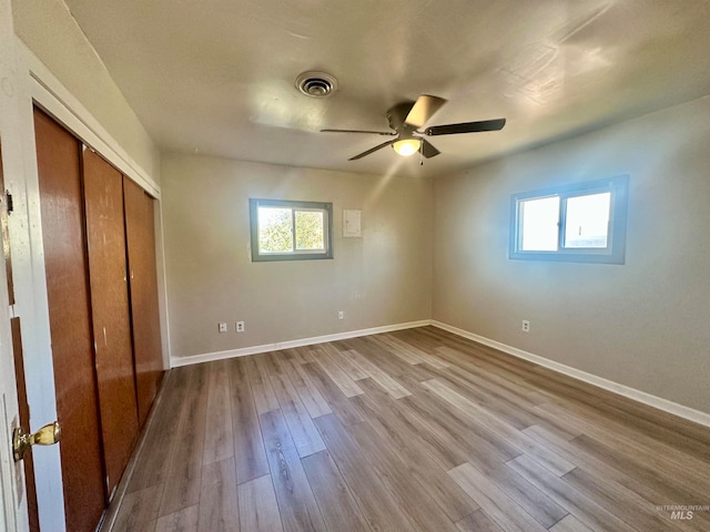 unfurnished bedroom featuring light hardwood / wood-style flooring, a closet, and ceiling fan