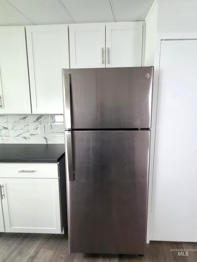 116 E 2nd St, Middleton, ID 83644 - kitchen featuring freestanding refrigerator, white cabinetry, dark countertops, wood finished floors, and tasteful backsplash