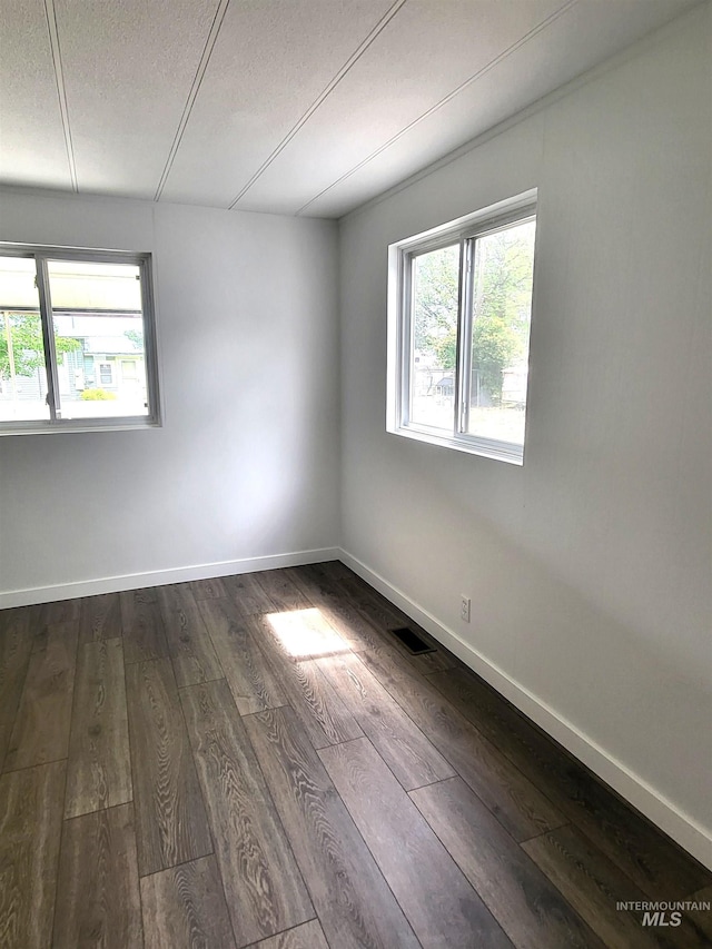 116 E 2nd St, Middleton, ID 83644 - unfurnished room with healthy amount of natural light, dark wood-style flooring, a textured ceiling, and baseboards