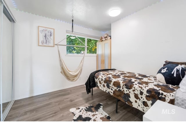 bedroom with baseboards and wood finished floors