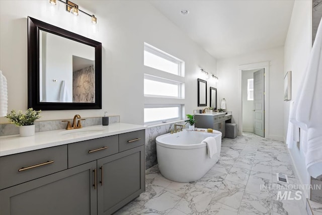 8820 E Snow Drop St, Nampa, ID 83687 - full bathroom with visible vents, a freestanding bath, two vanities, a sink, and marble finish floor