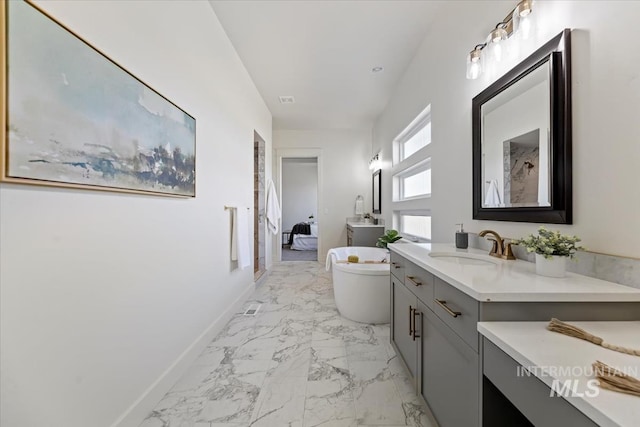 8820 E Snow Drop St, Nampa, ID 83687 - ensuite bathroom featuring vanity, marble finish floor, a freestanding tub, baseboards, and ensuite bath