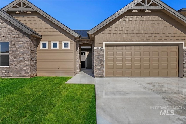 8820 E Snow Drop St, Nampa, ID 83687 - view of front of property with a front yard, driveway, stone siding, and a garage