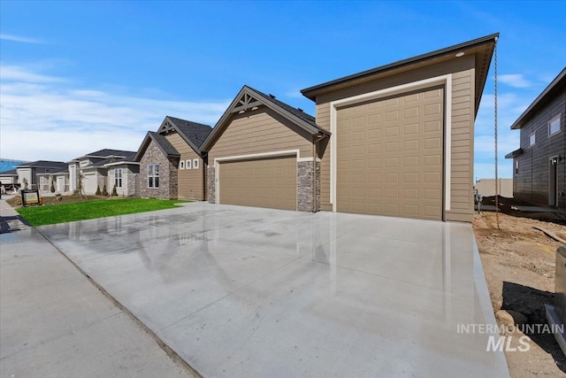 8820 E Snow Drop St, Nampa, ID 83687 - view of front of property with a garage, stone siding, concrete driveway, and a residential view
