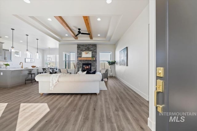 8820 E Snow Drop St, Nampa, ID 83687 - living room with light wood-style floors, a raised ceiling, a ceiling fan, and recessed lighting