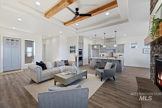 8820 E Snow Drop St, Nampa, ID 83687 - living area with beam ceiling, a stone fireplace, a ceiling fan, recessed lighting, and wood finished floors