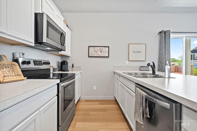 2312 E Spice Loop Unit 2, Nampa, ID 83687 - kitchen featuring stainless steel appliances, light wood-style floors, light countertops, white cabinets, and a textured ceiling