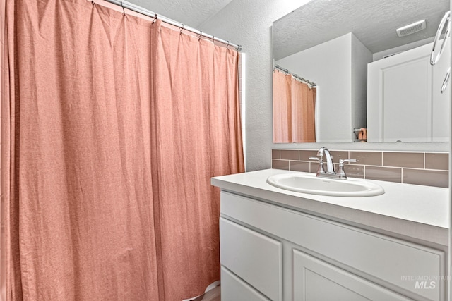 2312 E Spice Loop Unit 2, Nampa, ID 83687 - full bath featuring tasteful backsplash, vanity, a textured ceiling, and curtained shower