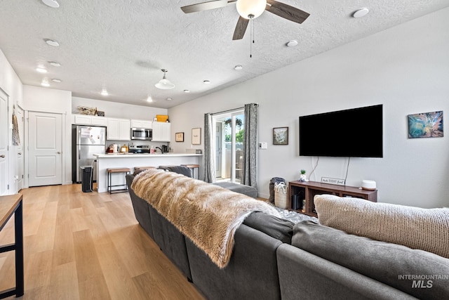 2312 E Spice Loop Unit 2, Nampa, ID 83687 - living area featuring light wood-style floors, a textured ceiling, and a ceiling fan