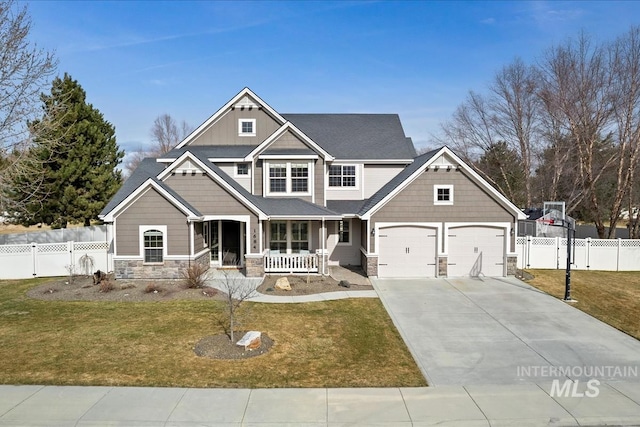 craftsman house featuring concrete driveway, stone siding, a porch, fence, and a front lawn