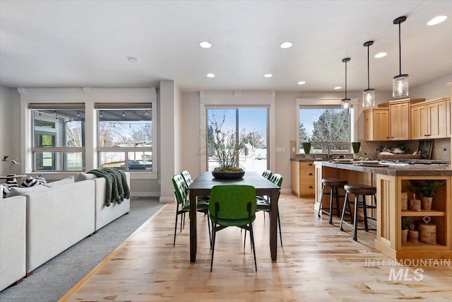 dining space with light wood-type flooring, baseboards, and recessed lighting