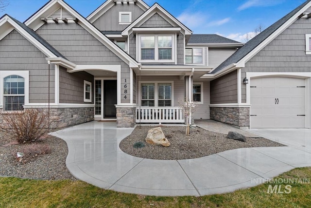 craftsman-style house featuring a garage, stone siding, a porch, and board and batten siding