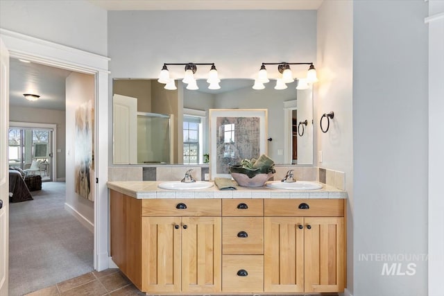 ensuite bathroom featuring double vanity, a shower stall, a sink, and ensuite bathroom