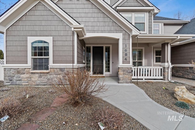 view of front of property featuring covered porch and stone siding