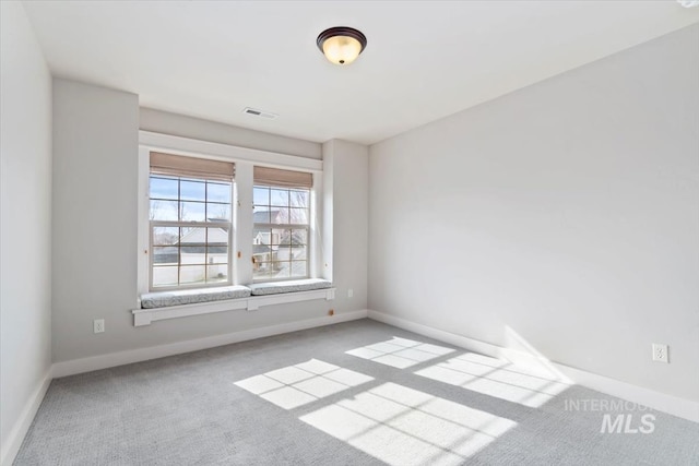 carpeted spare room with baseboards and visible vents