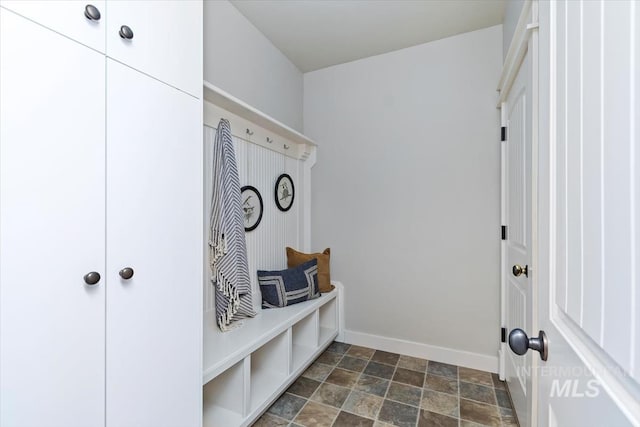 mudroom with stone finish flooring and baseboards