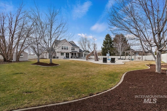 view of yard with a fenced backyard, stairway, an outbuilding, and a patio