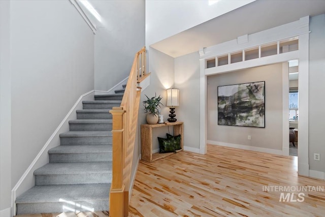 stairway with baseboards and wood finished floors