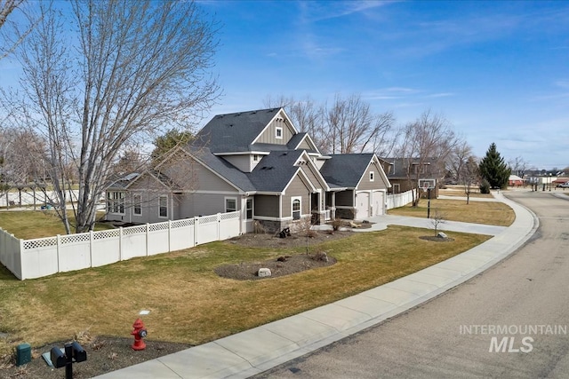 view of front of home featuring a residential view, fence, board and batten siding, and a front yard