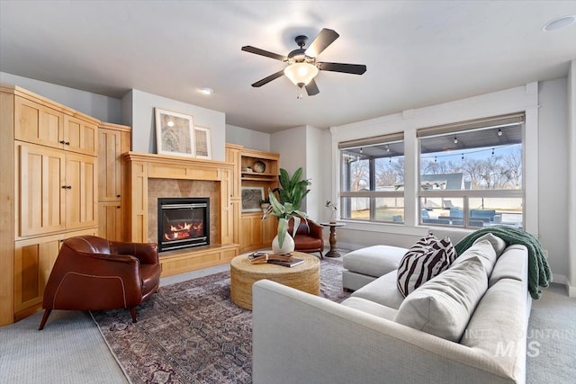 carpeted living room with a fireplace and a ceiling fan