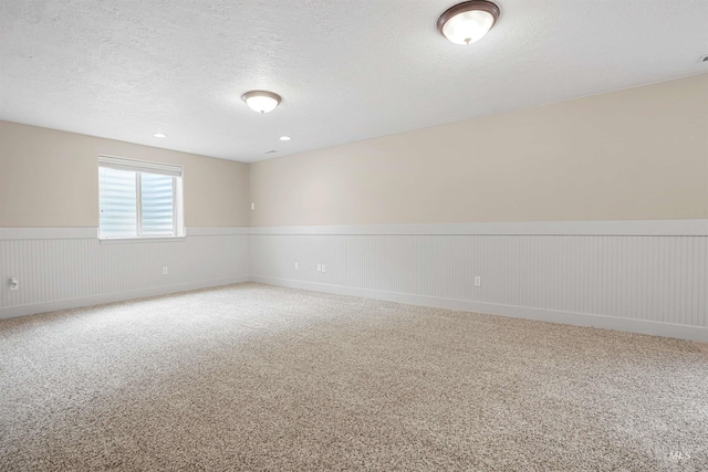 72 Pelican Dr, Rupert, ID 83350 - empty room featuring a wainscoted wall, light carpet, and a textured ceiling