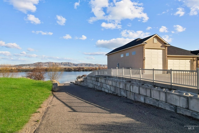 72 Pelican Dr, Rupert, ID 83350 - exterior space featuring stucco siding, fence, and a water and mountain view