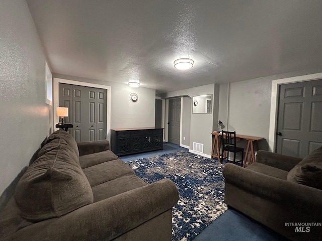 living room with a textured ceiling and carpet floors