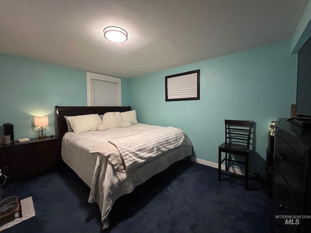 bedroom featuring a textured ceiling and dark carpet