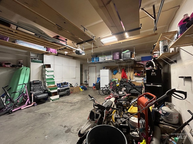 garage with a garage door opener and white refrigerator