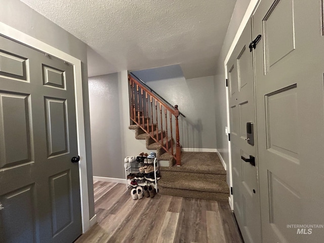 entryway with a textured ceiling and hardwood / wood-style floors