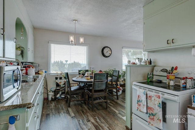 kitchen featuring dark hardwood / wood-style floors, electric range, a wealth of natural light, and a textured ceiling