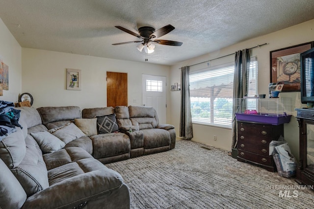 living room with carpet, a textured ceiling, and ceiling fan