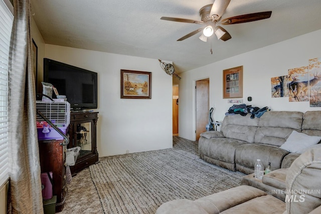 carpeted living room with a textured ceiling and ceiling fan