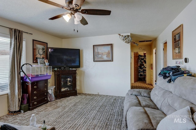 carpeted living room with ceiling fan and a textured ceiling