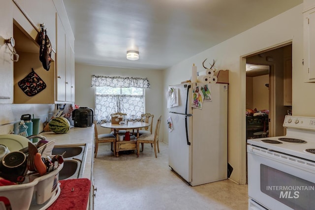 kitchen featuring white cabinetry, white appliances, and sink