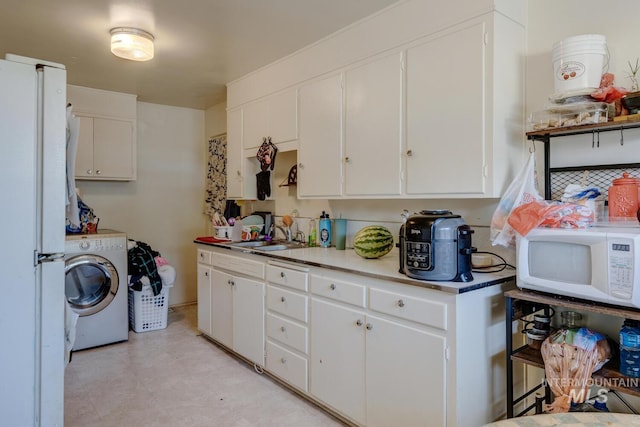 kitchen featuring white cabinetry, washer / dryer, white appliances, and light tile patterned floors